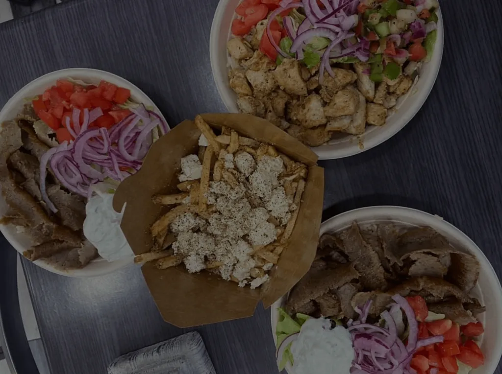 Takeout from Pita Bowl from above: a gyro bowl, chicken bowl and a box of feta-topped fries